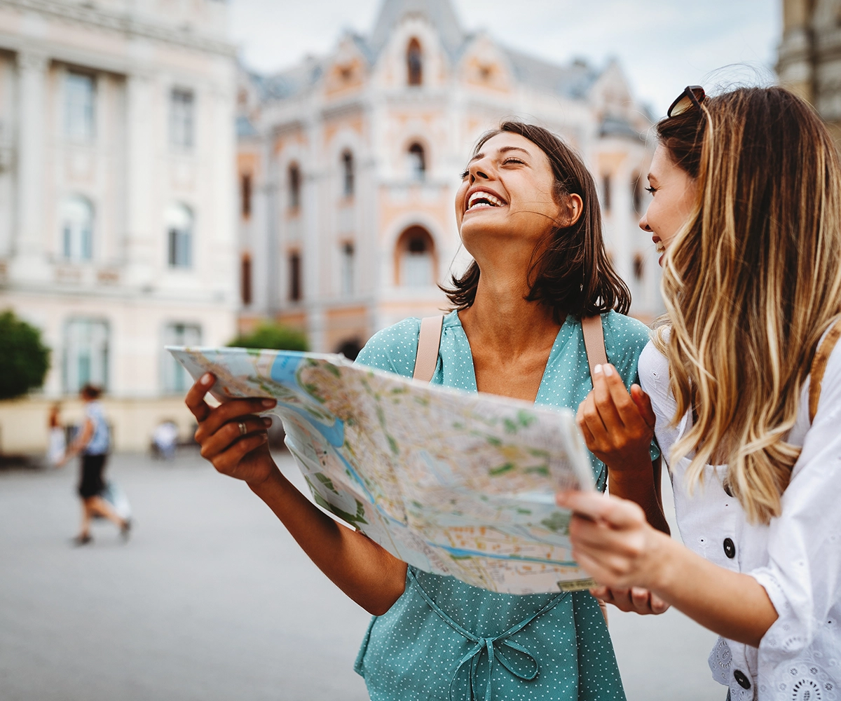 Happy women exploring France with a map