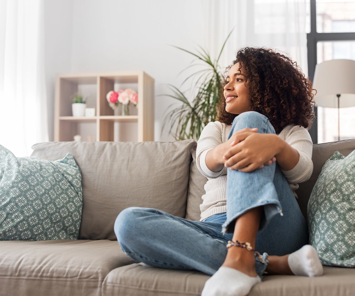 A woman sitting comfy on a sofa